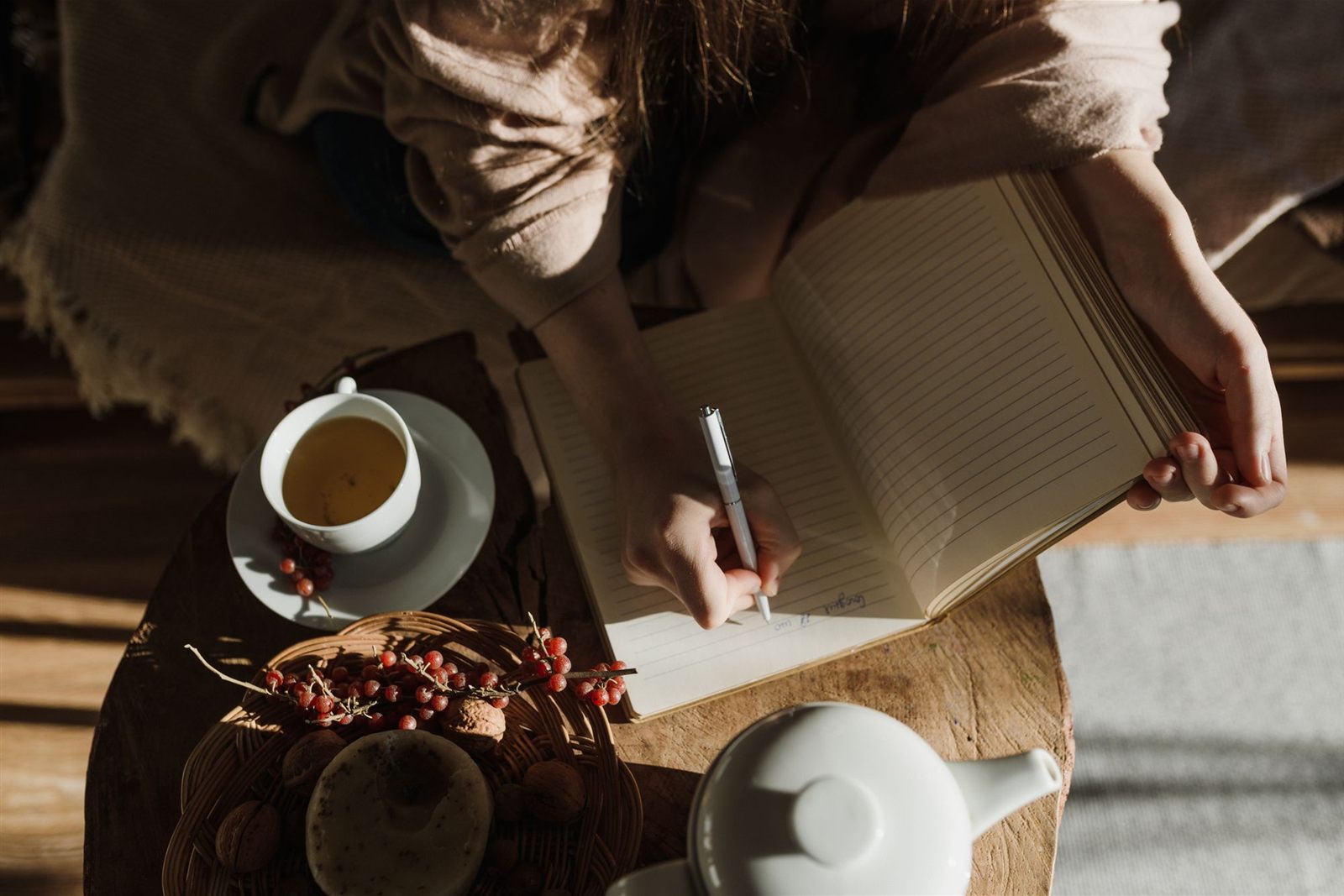 Writing in a journal with a cup of herbal tea